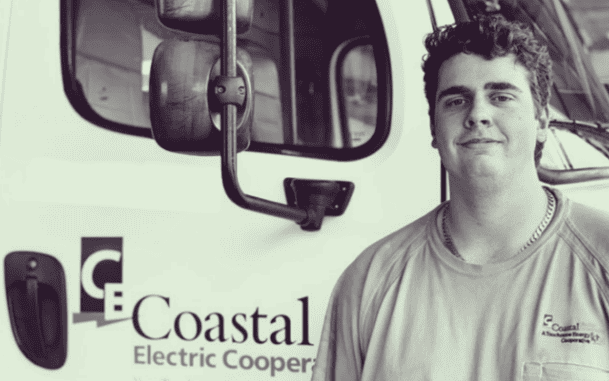 A lineworker poses by a co-op truck