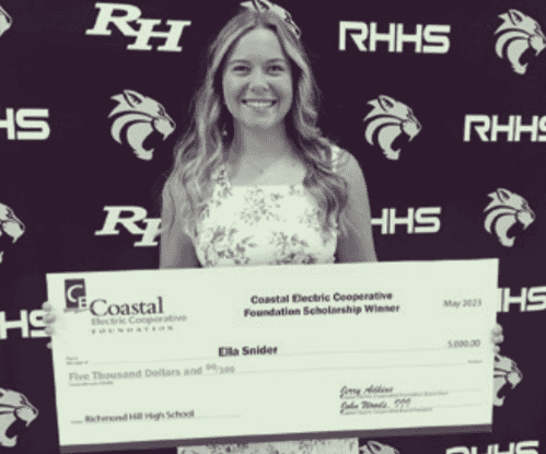 A scholarship winner poses with a big check