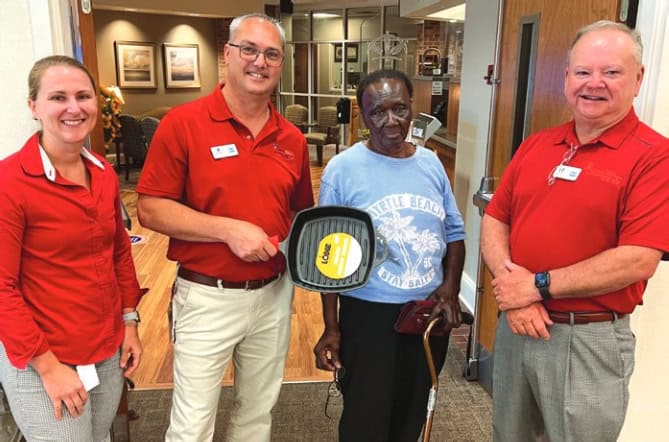 Ms. Rube receives her Lodge Skillet from staff members