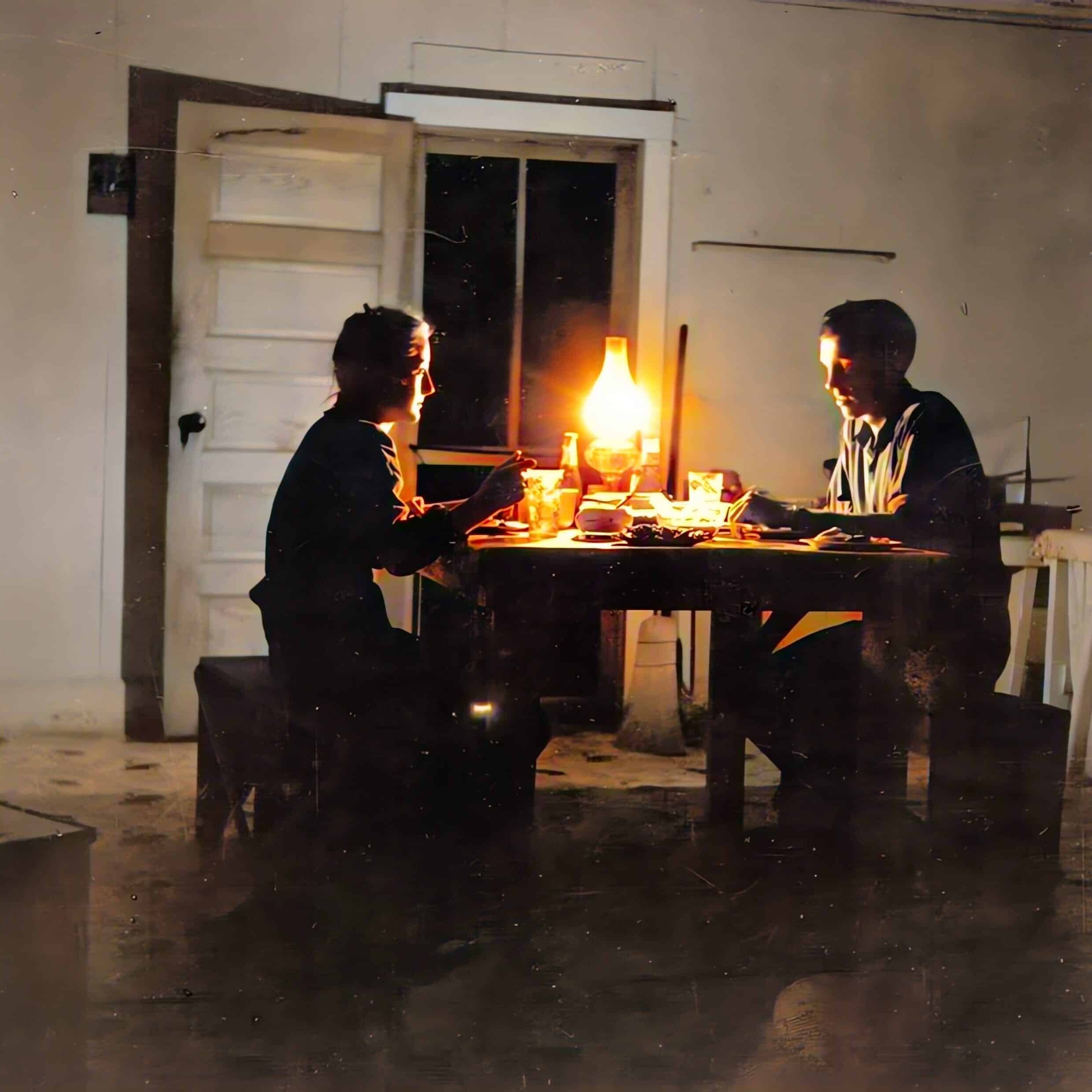 Rural couple eating dinner with kerosene lantern at the light source