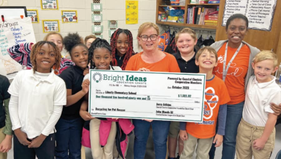 A teacher holds a Bright Ideas grant check