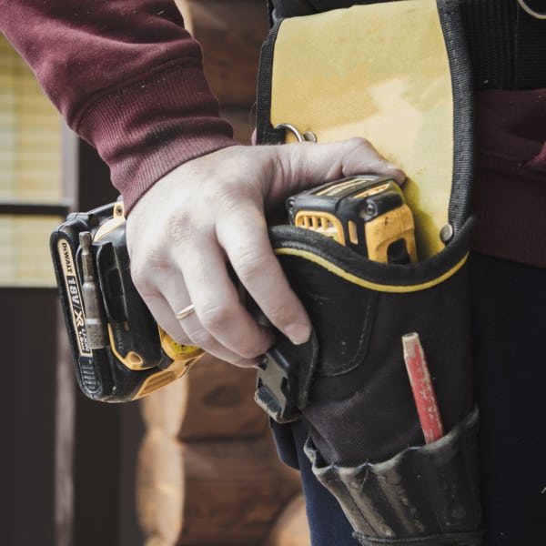 Man's hand holding a tape measure