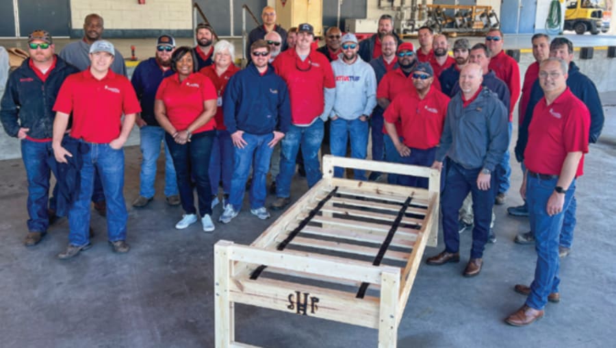 Coastal Electric Cooperative employees assemble one complete bed to showcase the finished product, which will go to a local child in need.
