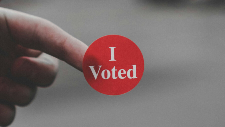 A man holds an "I voted" sticker